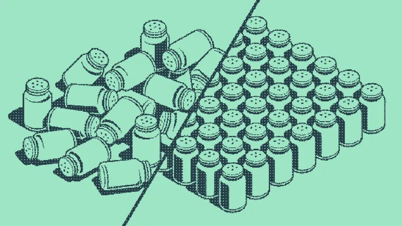 Salt shakers tumbled in a pile beside shakers standing in a neat grid